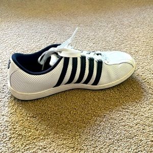 Pair of white with black stripes tennis shoes